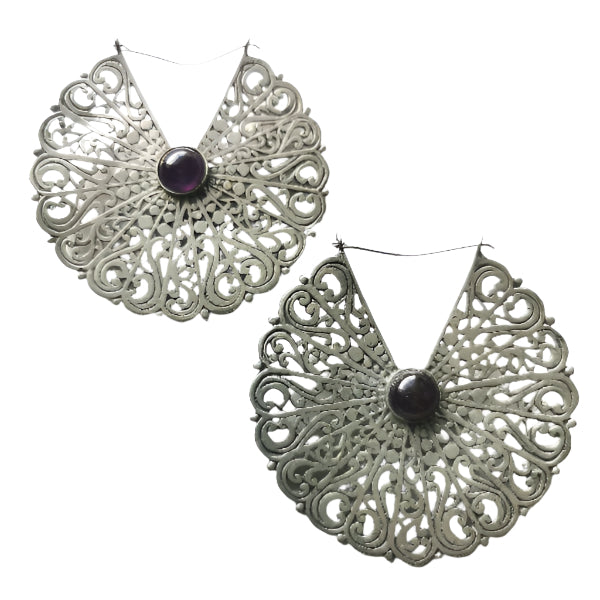 Ornate silver earrings with dark gemstones on a white background