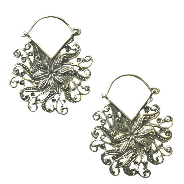 Pair of ornate brass earrings on a white background