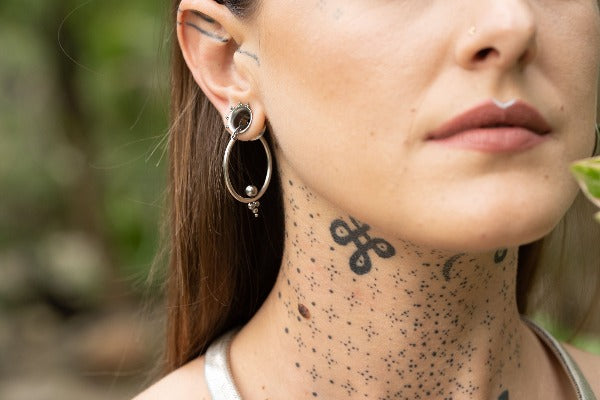 Stainless steel earrings - Triangle Dots on model wearing tunnels