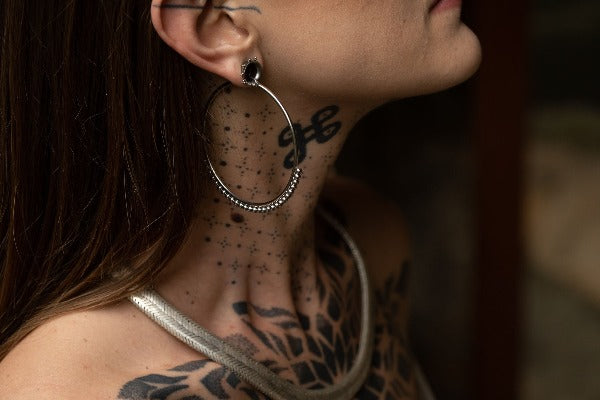 Stainless steel hoop earrings - Delicate Dotwork on model wearing tunnels