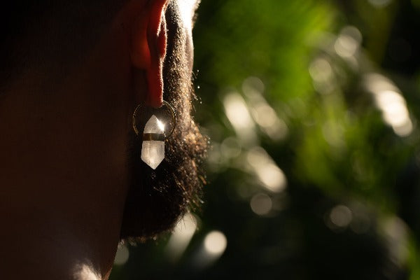 Brass ear weights with white quartz crystals on model with stretched ears