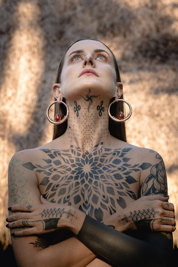 Rose gold plated clicker ear weights with Carnelian Teardrop - Mata Hari on model with stretched ears