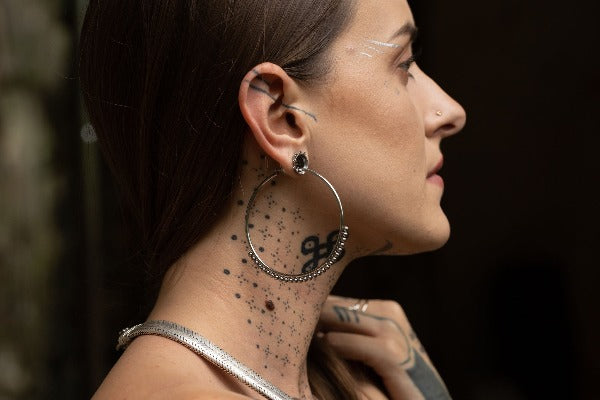 Stainless steel hoop earrings - Delicate Dotwork on model wearing tunnels